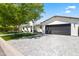 Stunning home exterior with a dark garage door, manicured lawn, and a paved driveway leading to the entrance at 3710 E Hazelwood St, Phoenix, AZ 85018
