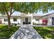 Inviting front yard featuring a modern home facade, lush lawn, mature tree, and manicured landscaping at 3710 E Hazelwood St, Phoenix, AZ 85018