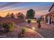 Desert landscaped backyard featuring a unique metal fire pit and ambient lighting at 3900 S Velero St, Chandler, AZ 85249