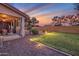 Beautifully lit backyard featuring a covered patio, lush grass, and desert landscaping at 3900 S Velero St, Chandler, AZ 85249