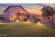 Illuminated backyard with lush grass and landscaping under a vibrant sunset sky at 3900 S Velero St, Chandler, AZ 85249