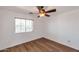 This bedroom has wood floors, a ceiling fan, and a large sunny window at 3900 S Velero St, Chandler, AZ 85249