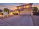 Inviting home exterior with a well-lit driveway, desert landscaping, and a freshly painted garage door at sunset at 3900 S Velero St, Chandler, AZ 85249