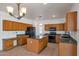 Spacious kitchen featuring ample wood cabinets, granite countertops, stainless steel appliances, and a center island at 3900 S Velero St, Chandler, AZ 85249