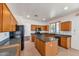 Modern kitchen boasts wood cabinetry, granite countertops, black appliances, and a functional center island at 3900 S Velero St, Chandler, AZ 85249