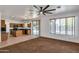 Open-concept living space with tile flooring, large windows, and a view of the kitchen area, with a large ceiling fan at 3900 S Velero St, Chandler, AZ 85249