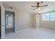 Bright bedroom with ceiling fan, built in closet and white tile flooring at 3946 W Monte Vista Rd, Phoenix, AZ 85009