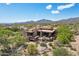 Majestic aerial view of the estate, nestled amidst picturesque desert landscape with scenic mountain views under a clear blue sky at 40215 N 110Th Pl, Scottsdale, AZ 85262