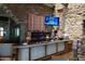 Stylish bar area featuring stone accents, a custom bar with lighting, and comfortable seating at 40215 N 110Th Pl, Scottsdale, AZ 85262
