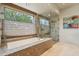 Relaxing bathroom featuring a soaking tub with stone trim and a glass-enclosed shower near a window at 40215 N 110Th Pl, Scottsdale, AZ 85262