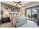Relaxing primary bedroom features neutral walls, ceiling fan, and sliding doors to a desert view patio at 40215 N 110Th Pl, Scottsdale, AZ 85262