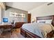 Comfortable bedroom with wood floors, a striped bedspread, a desk for working, and ample natural light at 40215 N 110Th Pl, Scottsdale, AZ 85262