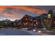A stunning exterior view of the clubhouse at dusk offers a warm welcome and scenic backdrop at 40215 N 110Th Pl, Scottsdale, AZ 85262