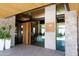 Elegant building entrance with stone accents, wooden details, and glass doors, creating an inviting and sophisticated welcome at 40215 N 110Th Pl, Scottsdale, AZ 85262