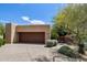 View of the home's garage showcasing a wide door and desert landscaping at 40215 N 110Th Pl, Scottsdale, AZ 85262