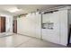 Spacious garage with an epoxy floor and ample storage space provided by white cabinets spanning the length of the back wall at 40215 N 110Th Pl, Scottsdale, AZ 85262