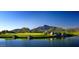 Scenic golf course view with water and rock features, set against a mountain backdrop under a clear blue sky at 40215 N 110Th Pl, Scottsdale, AZ 85262