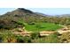 Beautiful green golf course with trees, desert vegetation, and mountain backdrop under a clear sky at 40215 N 110Th Pl, Scottsdale, AZ 85262