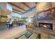 Inviting living room with a stone fireplace, exposed beams, and views into the dining area and outdoor scenery at 40215 N 110Th Pl, Scottsdale, AZ 85262