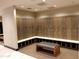 Well-maintained locker room with wood lockers and a comfortable bench offers a private and secure storage solution at 40215 N 110Th Pl, Scottsdale, AZ 85262