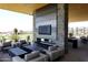 Inviting outdoor lounge area with cozy seating, a stone fireplace, and scenic views of the golf course, creating a relaxed atmosphere at 40215 N 110Th Pl, Scottsdale, AZ 85262