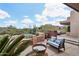 Beautiful outdoor patio featuring cozy seating arrangements, a fire pit, and a desert landscape backdrop under a sunny sky at 40215 N 110Th Pl, Scottsdale, AZ 85262