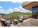 Inviting patio with comfortable seating, a hot tub, and views of lush desert landscape under a partly cloudy sky at 40215 N 110Th Pl, Scottsdale, AZ 85262