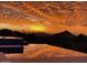 Picturesque infinity pool reflecting a vibrant sunset sky with mountain views at 40215 N 110Th Pl, Scottsdale, AZ 85262