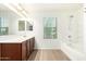 Bright bathroom featuring a shower-tub combo, wood cabinets, and modern finishes at 4149 E Devon Dr, Gilbert, AZ 85296
