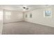 Spacious carpeted bedroom featuring three windows letting in natural light and a ceiling fan at 4149 E Devon Dr, Gilbert, AZ 85296