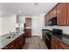 Well-equipped kitchen with dark cabinets, black appliances, and an island sink for efficient cooking at 4149 E Devon Dr, Gilbert, AZ 85296