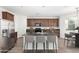 Bright kitchen features dark cabinets, stainless steel appliances, an island and bar stool seating at 4149 E Devon Dr, Gilbert, AZ 85296