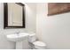 This powder room features a pedestal sink, a dark framed mirror, and neutral decor at 4149 E Devon Dr, Gilbert, AZ 85296