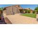 Backyard features a covered patio, pavers, easy-care turf, and mature trees at 42505 W Venture Rd, Maricopa, AZ 85138