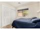 Bedroom featuring a blue comforter, wood-look flooring, and a large window at 42505 W Venture Rd, Maricopa, AZ 85138