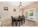 Charming dining room with a four-chair table set, neutral wall paint and access to outdoor patio at 42505 W Venture Rd, Maricopa, AZ 85138