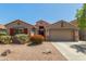 Inviting single-story home featuring a two-car garage and beautifully landscaped front yard with desert landscaping at 42505 W Venture Rd, Maricopa, AZ 85138