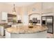 Spacious kitchen with granite countertops, stainless steel appliances, and a large island with breakfast bar at 42505 W Venture Rd, Maricopa, AZ 85138