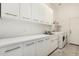 Laundry room featuring white cabinets, a sink, and a washer and dryer at 42505 W Venture Rd, Maricopa, AZ 85138