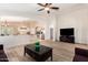 Bright, open-concept living room featuring wood-look tile floors and a seamless flow to the kitchen at 42505 W Venture Rd, Maricopa, AZ 85138