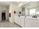 Bright bathroom features dual sinks, white cabinets, and a large mirror at 5612 N 109Th Ave, Phoenix, AZ 85037