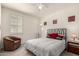 Bright bedroom featuring a ceiling fan, comfortable bed, and a cozy sitting chair at 5612 N 109Th Ave, Phoenix, AZ 85037