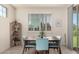 Bright dining room with natural light, shuttered windows and modern table with blue chairs at 5612 N 109Th Ave, Phoenix, AZ 85037