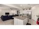 Open concept kitchen, white cabinets, stainless appliances, granite island and adjacent living space at 5612 N 109Th Ave, Phoenix, AZ 85037