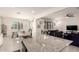 Open concept kitchen, white cabinets, stainless appliances, granite island and adjacent living space at 5612 N 109Th Ave, Phoenix, AZ 85037