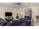 Cozy living room featuring a ceiling fan and a comfortable blue sectional sofa at 5612 N 109Th Ave, Phoenix, AZ 85037