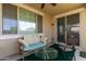Comfortable covered patio featuring a cozy bench, cushioned chairs, and natural light at 5612 N 109Th Ave, Phoenix, AZ 85037
