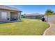 Spacious backyard featuring lush green grass and a covered patio with a built-in grill at 6319 W Hilton Ave, Phoenix, AZ 85043