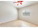 Bright bedroom with tiled flooring, ceiling fan, and window providing natural light at 6319 W Hilton Ave, Phoenix, AZ 85043