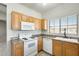 Well-lit kitchen features white appliances, wooden cabinets and a large window with natural light at 6319 W Hilton Ave, Phoenix, AZ 85043